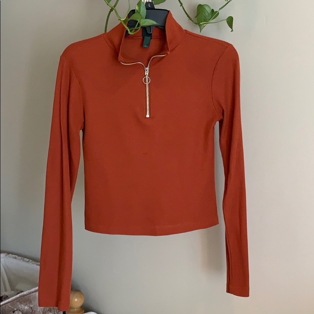 Orange half zip long sleeve top.